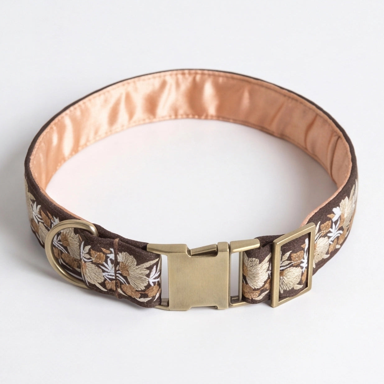 Dog collar with floral pattern and gold buckle on a white background