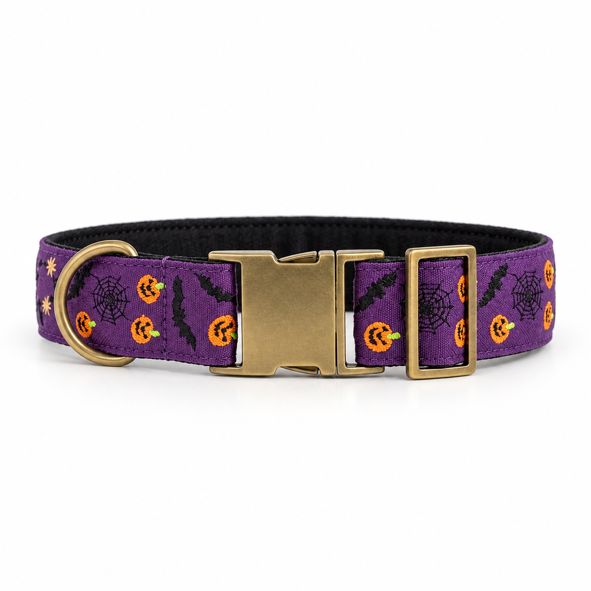 A purple dog collar with a Halloween pattern of orange pumpkins, black bats, spiderwebs, and stars, featuring a brass buckle and D-ring, shown on a white background.