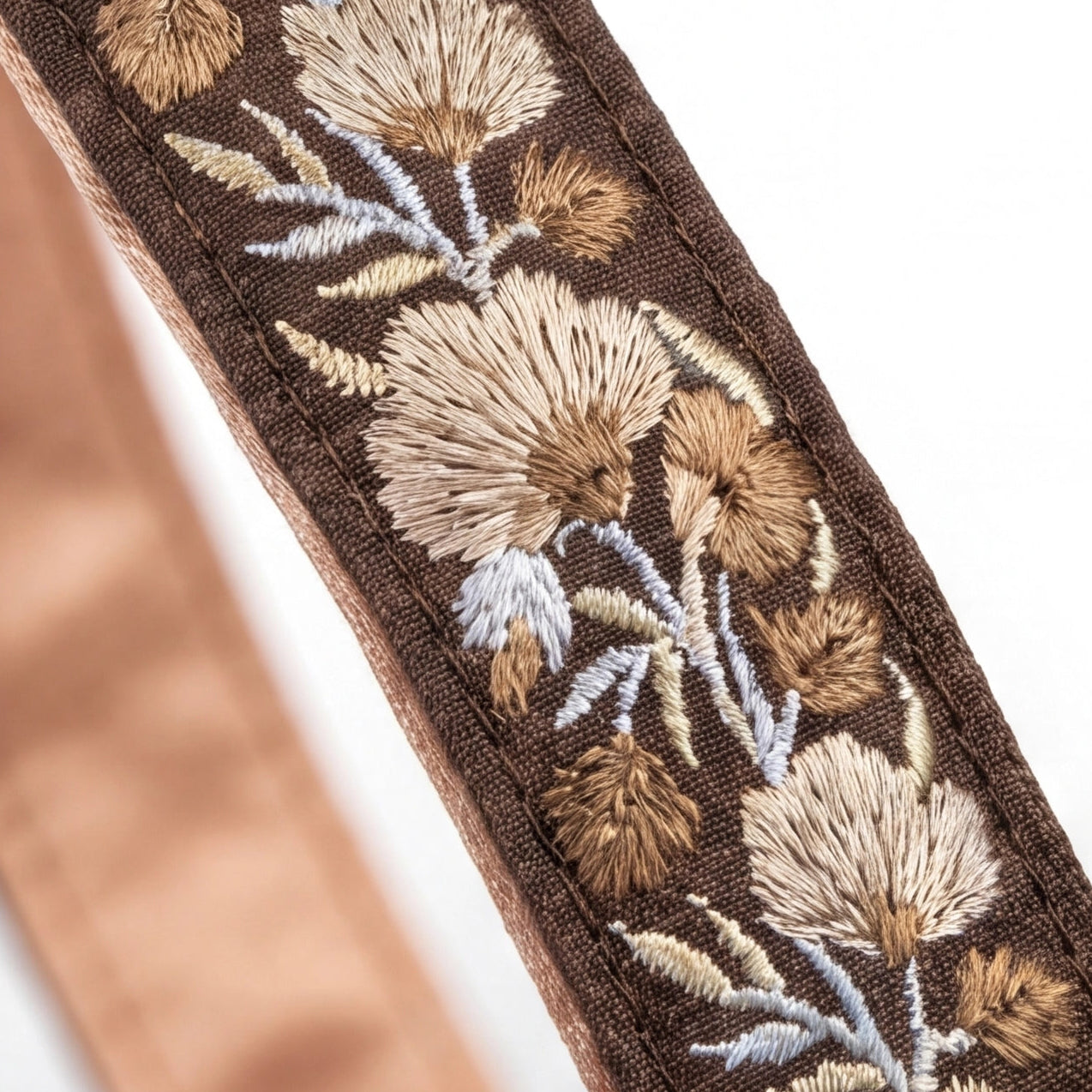 Close-up of an embroidered belt with floral patterns on a brown fabric