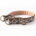A brown fabric dog collar with an embroidered floral pattern in beige, white, and brown, featuring antique brass hardware, including a D-ring, buckle, and adjustment slider.