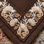 Close-up of brown fabric with intricate floral embroidery