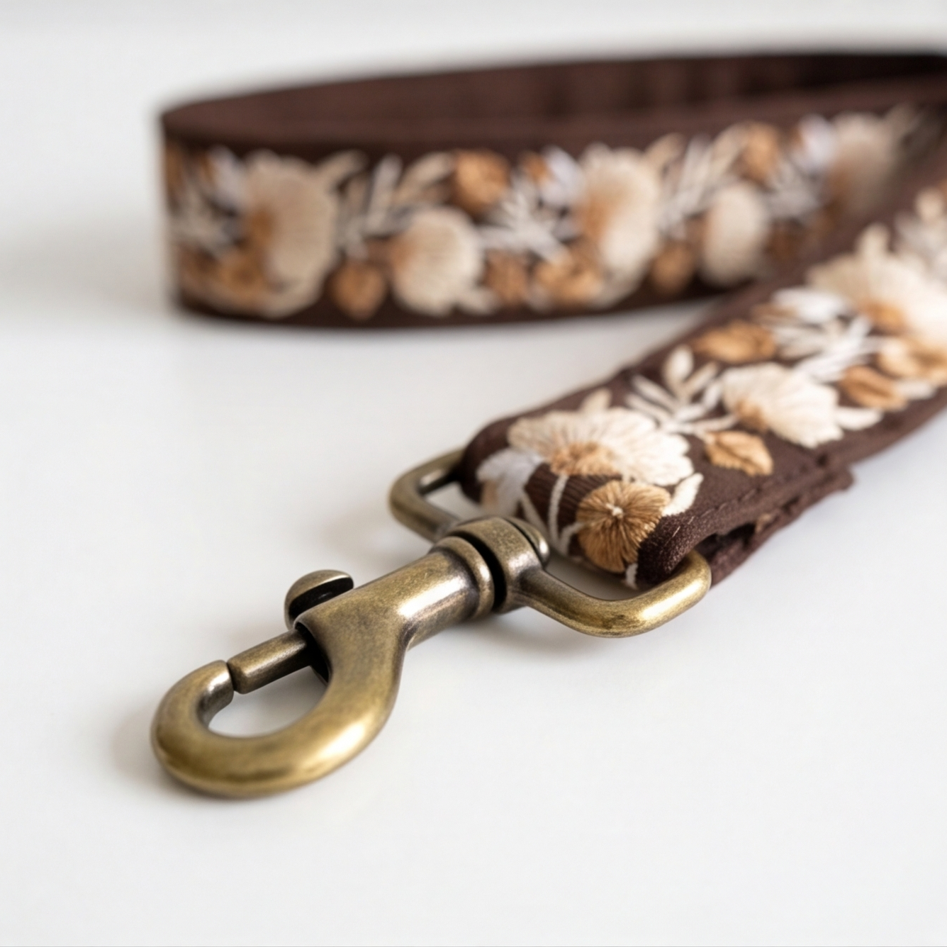 Floral-patterned dog leash with brass clasp on a white background