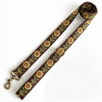 A floral-patterned leash with antique metal hardware on a white background
