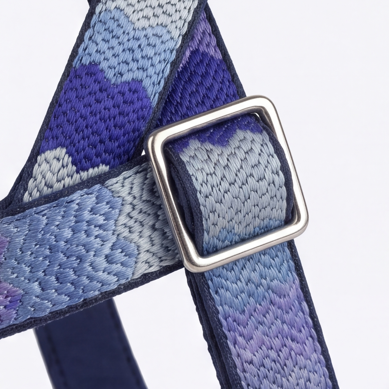 Blue and gray patterned strap with a silver buckle on a white background
