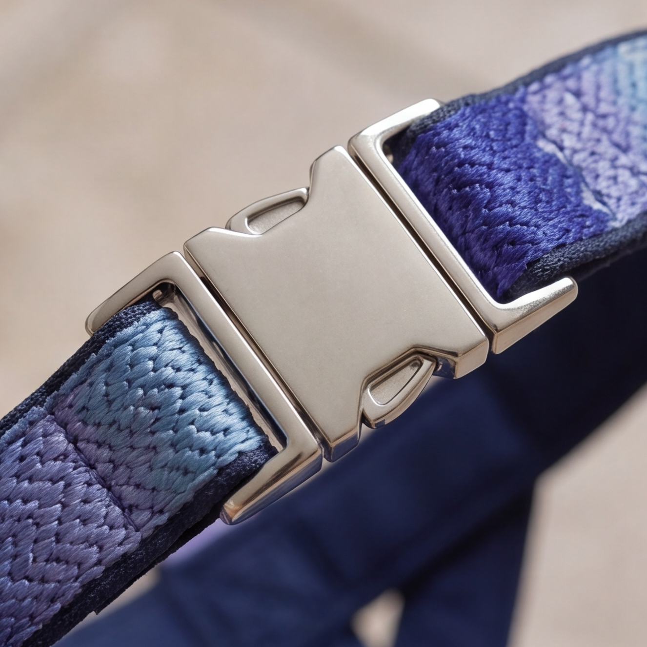 Close-up of a blue textured blue harness with a silver buckle on a neutral background