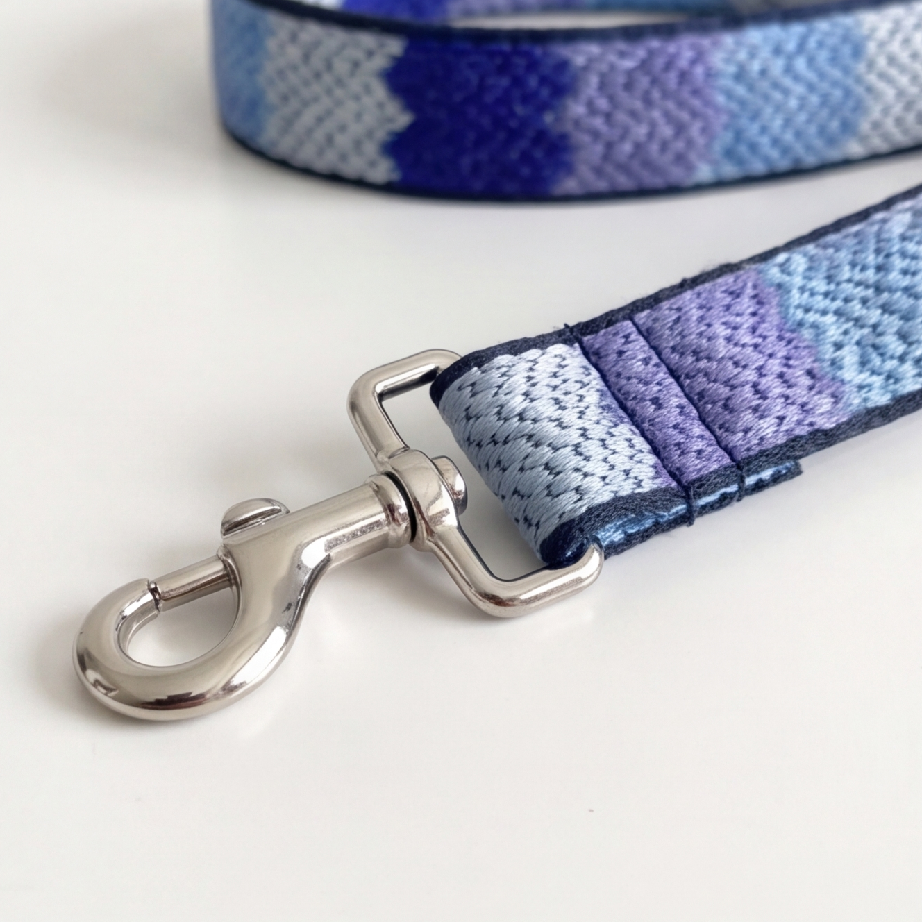 Dog leash with colorful pattern and metal clasp on a white background