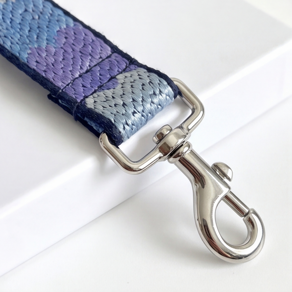 Leash with purple and blue pattern and silver dog hook on a white background