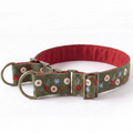 A green embroidered dog collar with a red interior lining, featuring decorative floral and snowflake patterns, brass hardware, and a red D-ring, shown on a white background.
