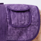 A close-up of a purple herringbone-patterned dog coat with a matching elastic strap and a front flap pocket, shown on a small dog against a white background.