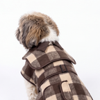 A small fluffy dog shown from the back wearing a brown and beige plaid coat with dark brown trim, photographed against a clean white background.