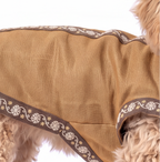 A tan dog coat with a brown and white floral patterned trim, shown on a light-colored dog against a white background.
