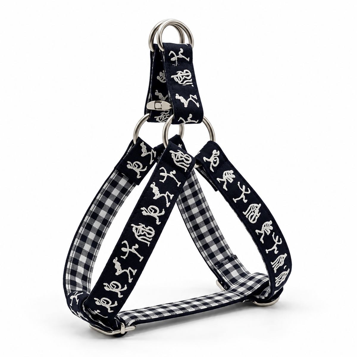 A triangular dog harness with black and white gingham fabric straps, featuring white dog silhouettes printed on the black outer bands, and silver metal hardware.